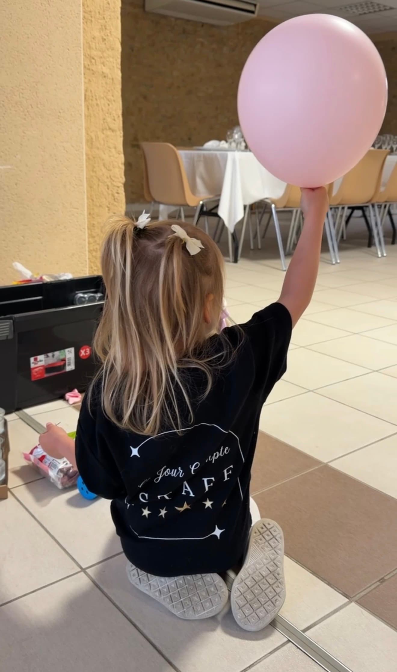 Une petite main de la famille Ce Jour Compte avec un ballon géant