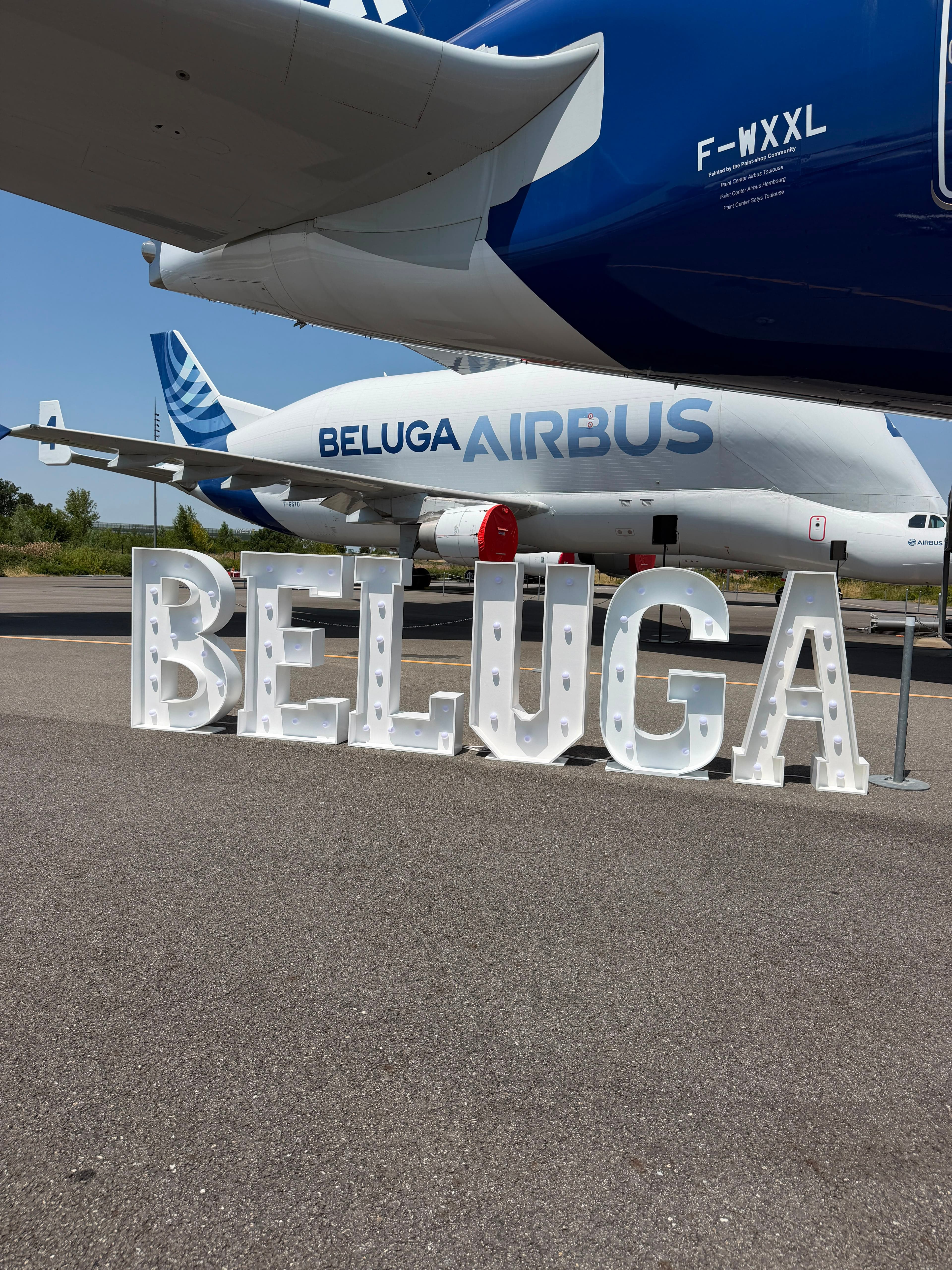 Lettres lumineuses géantes BELUGA devant l'avion Airbus Beluga